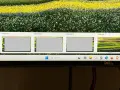Widok czterech pulpitów Windows 10, z czego trzy są szare, a czwarty pokazuje kolorowy krajobraz. Pasek zadań z wyszukiwarką i ikonami.