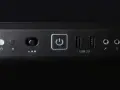 Przycisk zasilania z ikoną symbolizującą skrót klawiszowy uruchom ponownie, obok porty USB 3.0 i gniazda audio.