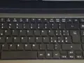 Klawiatura laptopa z włoskim układem klawiatury. Widoczne klawisze z literami, cyframi i symbolami, w tym € i accented vowels.