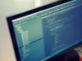 Programista pracuje nad kodem PHP. Format komputera pozwala na szybkie tworzenie i edycję skomplikowanych projektów.