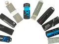 Różne modele pendrive'ów, czyli przenośnych pamięci USB, ułożone w łuk. Widać marki Kingston, ADATA, SanDisk, Patriot, Transcend, MX-TECHNOLOGY.
