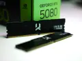 Dwa moduły pamięci RAM IRDM DDR5 leżą przed zielonym pudełkiem karty graficznej GeForce RTX 5080.