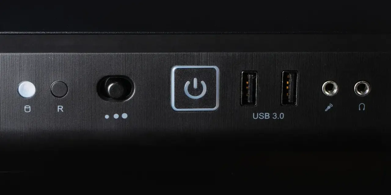 Przycisk zasilania z ikoną symbolizującą skrót klawiszowy uruchom ponownie, obok porty USB 3.0 i gniazda audio.