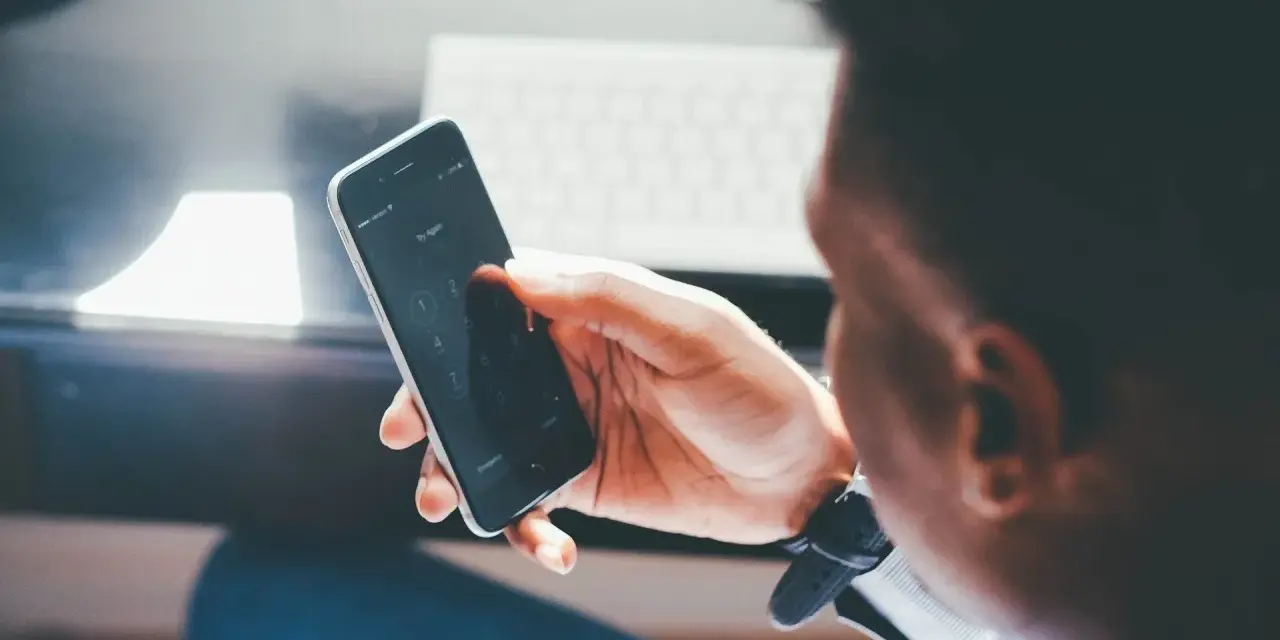 Mężczyzna próbuje odblokować telefon, być może w obawie przed działaniami hakerów w internecie.