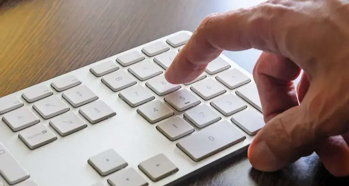 Dłoń naciska klawisz 8 na klawiaturze. W tle widać klawisz Windows.