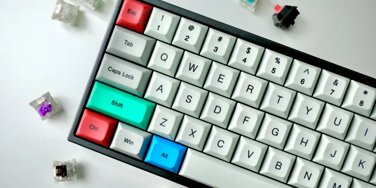Klawiatura z kolorowymi klawiszami i przełącznikami. Klawisz "Alt" jest niebieski, "Ctrl" czerwony, a "Shift" turkusowy. To idealne miejsce do nauki skrótów klawiszowych, np. skrót klawiszowy szukaj.