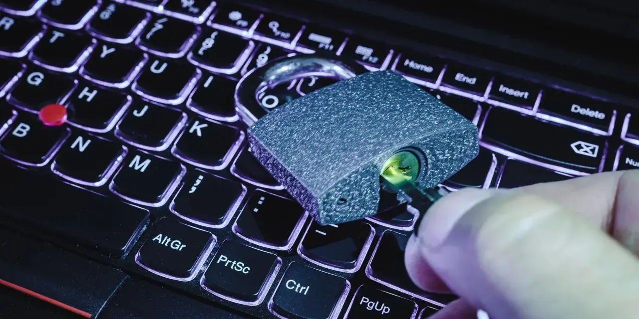 Klucz w zamku na klawiaturze laptopa. Symbolizuje to, jak sprawdzić czy plik ma wirusa i chronić dane.