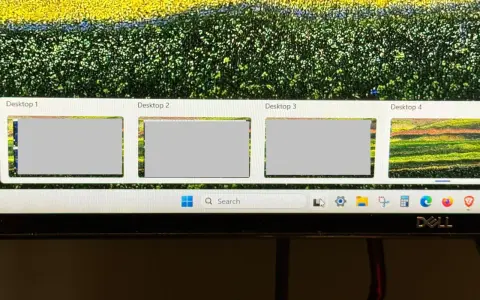 Widok czterech pulpitów Windows 10, z czego trzy są szare, a czwarty pokazuje kolorowy krajobraz. Pasek zadań z wyszukiwarką i ikonami.