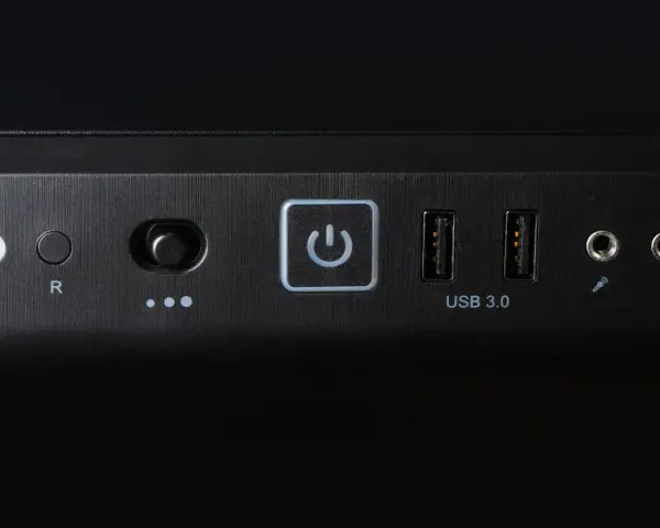 Przycisk zasilania z ikoną symbolizującą skrót klawiszowy uruchom ponownie, obok porty USB 3.0 i gniazda audio.