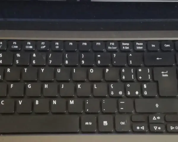 Klawiatura laptopa z włoskim układem klawiatury. Widoczne klawisze z literami, cyframi i symbolami, w tym € i accented vowels.