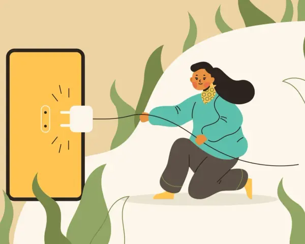 Kobieta podłącza wtyczkę do gniazdka na ekranie telefonu, symbolizując zużycie energii. Zastanawiasz się, ile prądu zużywa komputer?