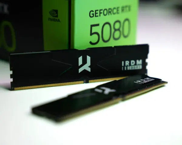 Dwa moduły pamięci RAM IRDM DDR5 leżą przed zielonym pudełkiem karty graficznej GeForce RTX 5080.