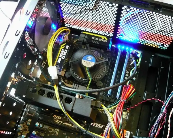 Wnętrze komputera z podświetlaną płytą główną MSI i wentylatorem Intel. Pokazuje, jak działa komputer, z widocznymi kablami i elementami.
