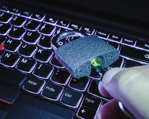 Klucz w zamku na klawiaturze laptopa. Symbolizuje to, jak sprawdzić czy plik ma wirusa i chronić dane.