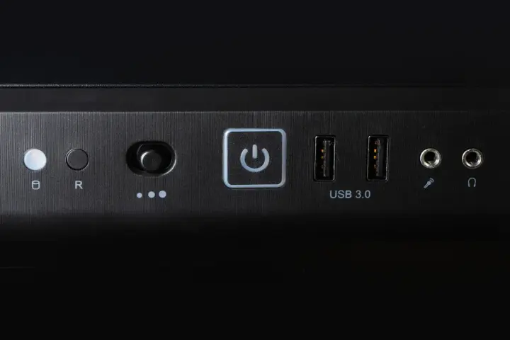 Przycisk zasilania z ikoną symbolizującą skrót klawiszowy uruchom ponownie, obok porty USB 3.0 i gniazda audio.