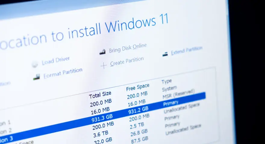 Ekran instalacji Windows 11 pokazuje opcje partycjonowania dysku. Dowiedz się, jak sformatować komputer Windows 11, wybierając odpowiednią partycję.