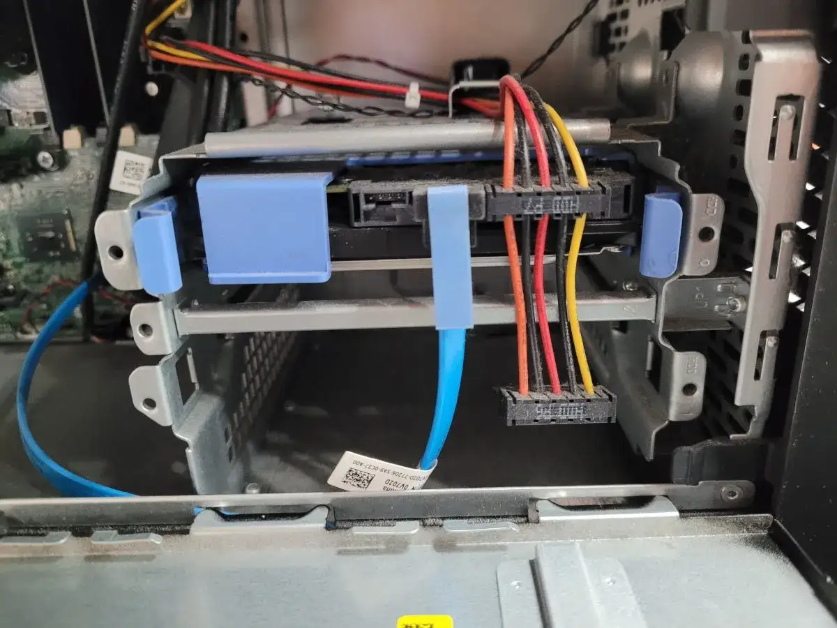 Wnętrze komputera z widocznym dyskiem SSD i kablami SATA, gotowe do podłączenia drugiego dysku SSD.