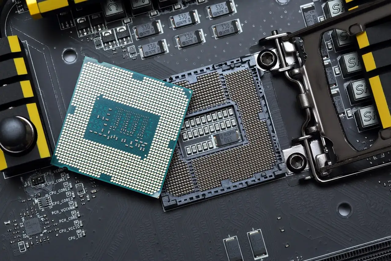 Por&oacute;wnanie procesor&oacute;w w laptopach: jeden CPU leży obok gniazda na płycie gł&oacute;wnej, gotowy do montażu.